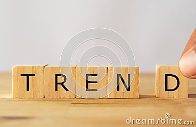 Hand man try to complete the Trend word on wooden cube, Trend concept Stock Photo