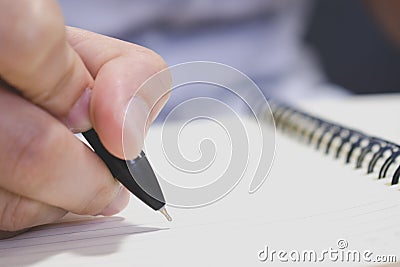 The hand of a man writing a book with a pen. Clouse up Stock Photo