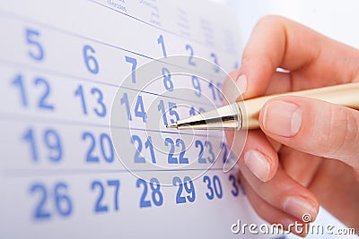 Hand marking date 15 on calendar Stock Photo