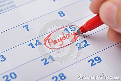 Hand Marking Payday On Calendar Stock Photo