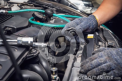 Hand of Mechanic check water in car radiator and add water antIfreeze coolant fluid to car radiator at garage , service and Stock Photo
