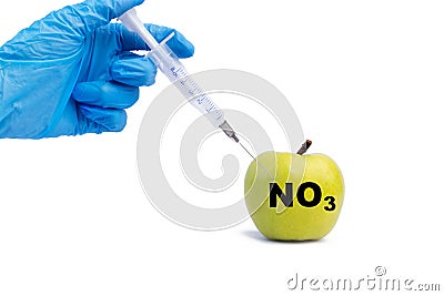 A hand in a medical glove inserts a syringe into a green apple with an inscription NO3 on a white background. Harmful food Stock Photo