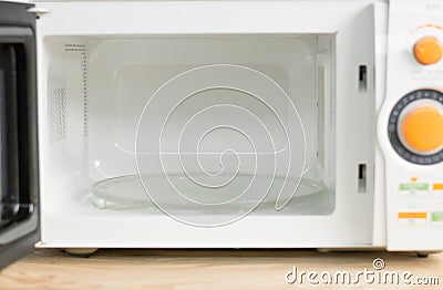 Hand with microfiber cleaning rag wiping inside of microwave oven, Stock Photo