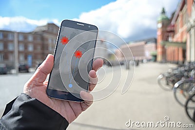 Hand with mobile phone and coronavirus tracking app via bluetooth against the spread of the pandemic, but controversial when it Stock Photo