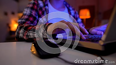 Hand of nervous boy pressing key, playing video games on laptop, addiction Stock Photo