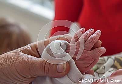 The hand of a newborn held by an old person Stock Photo