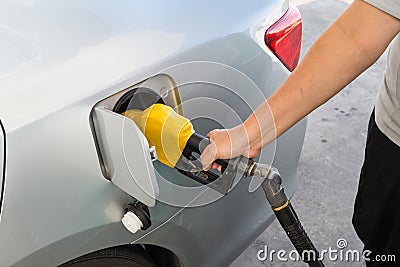 Hand with nozzle fueling unleaded gasoline into car Stock Photo