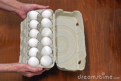 Hand of old Woman holds box eggs Stock Photo