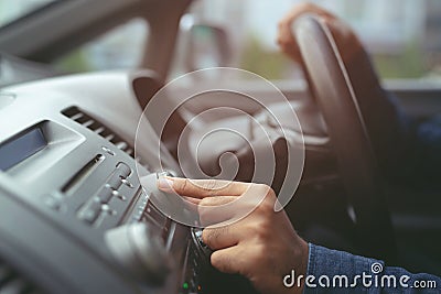 hand open car radio listening. Car Driver changing turning button Radio Stations on His Vehicle Multimedia System. Stock Photo