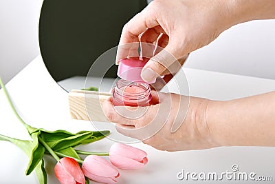 Hand opening natural skincare bottle, Cosmetic bottle containers packaging with tulip flower essence Stock Photo