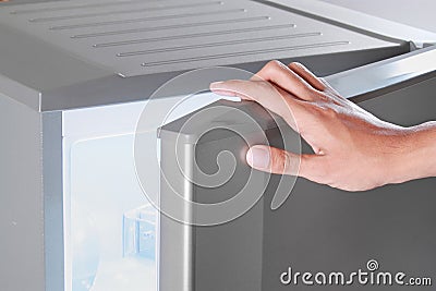 Hand opening refrigerator Stock Photo