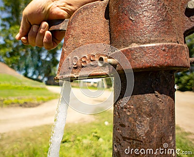 Hand opens the water on the water pump Stock Photo