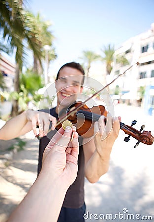 Hand paying money to busker man playing violin Stock Photo