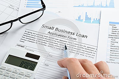 Hand with pen and calculator on loan application Stock Photo