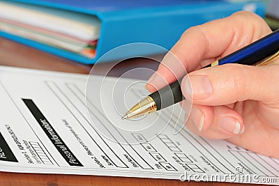 Hand with Pen Completing Personal Info on Form Stock Photo