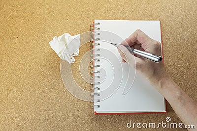 Hand with pen writing on blank spiral notebook. Stock Photo