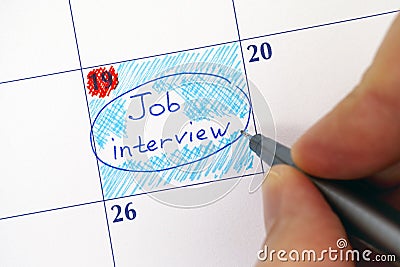 Hand with pen writing reminder Job Interview in calendar Stock Photo