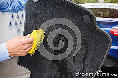 The hand of the person cleans an automobile rug Stock Photo