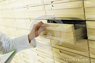 Hand of pharmaceutist opening drawer in farmacy Stock Photo