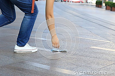 Hand pick up lost money from ground Stock Photo