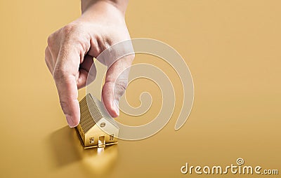 Hand picking golden house, real estate investment and buying home concept Stock Photo