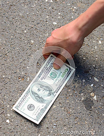 Hand picking money from street floor Stock Photo