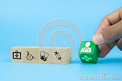 Hand picking up doctor icon on cube wooden toy blocks with medical icons. Stock Photo