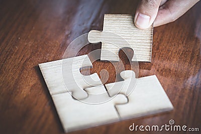 Hand placed the last piece of jigsaw puzzle, conceptual of problem solving, finding a solution Stock Photo
