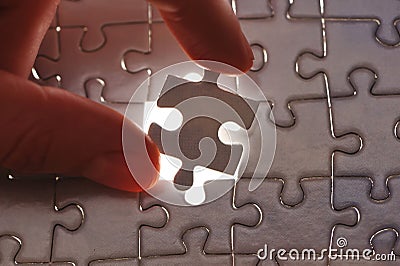 Hand placing missing puzzle piece Stock Photo