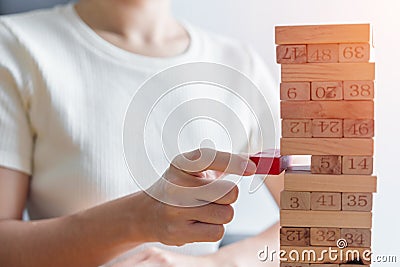 Hand placing or pulling wooden block on the tower. Business planning, Decision, Risk Management, Solution and strategy Conceptual Stock Photo