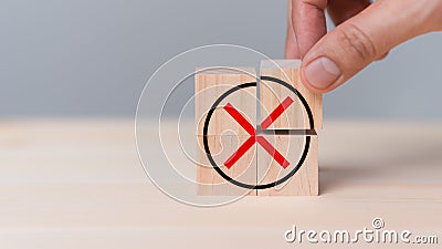 Hand placing wooden cube with red cross checkmark sign. Goals achievement and business success. Stock Photo