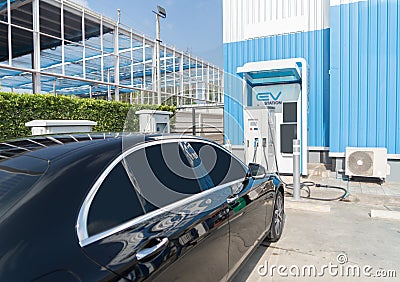 Hand plugging in EV car charger or electric vehicle. Cable connect to gas station,power supply battery charging an alternative Editorial Stock Photo