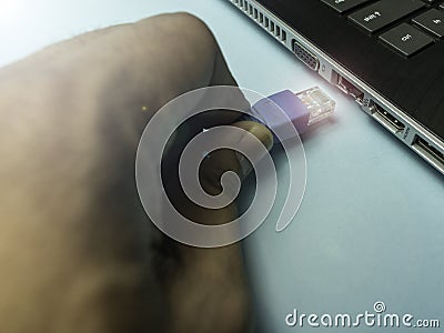 Hand plugging in the internet cable to a laptop Stock Photo