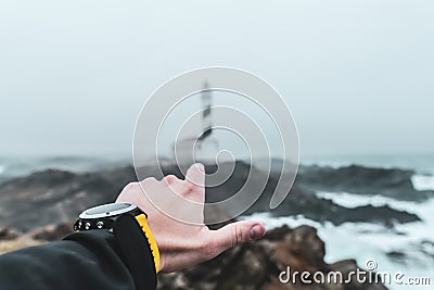 Hand pointing with finger a sea lighthouse Stock Photo
