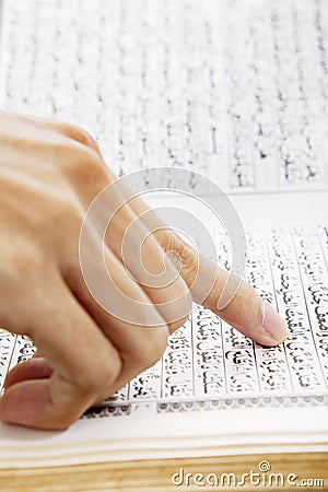 Hand pointing at paragraph of quran Stock Photo