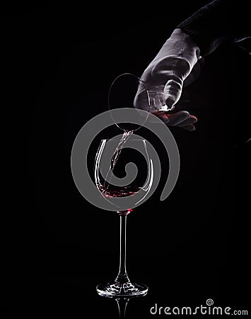 Hand pour red wine from decanter to glass Stock Photo