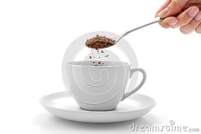 Hand pours instant coffee from a spoon in a coffee cup Stock Photo