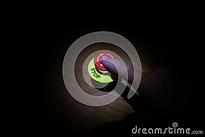Hand press on big red button grounge background. Red button on table in dark low key background Stock Photo