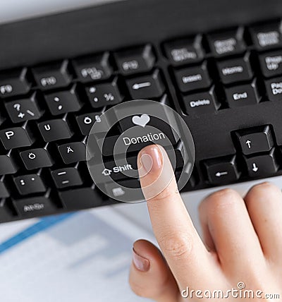 hand pressing donation button on keyboard Stock Photo