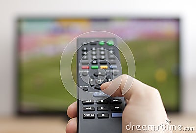 Hand pressing remote control Stock Photo