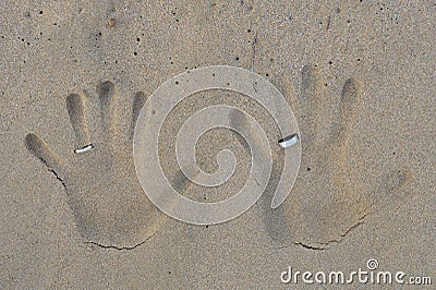 Hand prints with wedding bands on beach sand Stock Photo