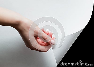 Hand pulling a paper corner to uncover, reveal something Stock Photo