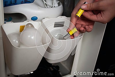 Hand puts the used batteries in a container for separate storage Stock Photo