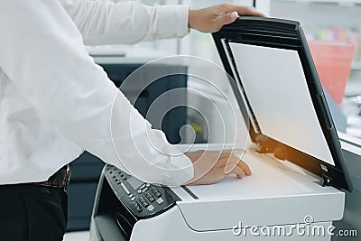 Hand putting a document paper into printer scanner or laser copy machine in office Stock Photo