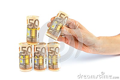 Hand putting down rolls of euro notes Stock Photo