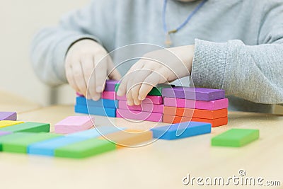 A hand is putting last cube on the top of pyramide Stock Photo