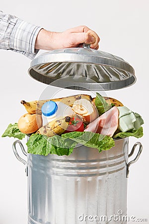 Hand Putting Lid On Garbage Can Full Of Waste Food Stock Photo