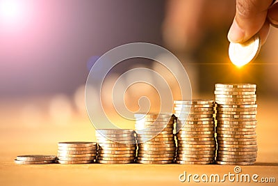 A hand putting money coins stack for save money concept. Stock Photo