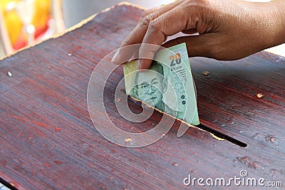 Hand putting money to donate Stock Photo