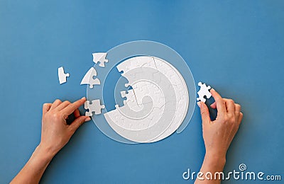Hand putting piece in round puzzle Stock Photo